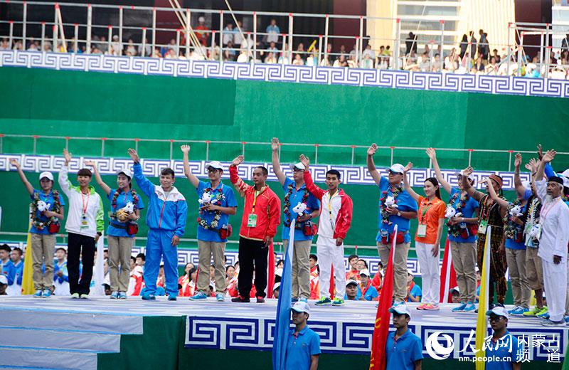 获奖运动员代表向本届民族运动会志愿者代表献花