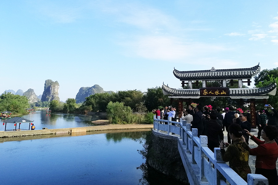 游客在山水人家景区前拍照